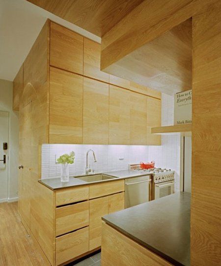 厨房的原木材质使用，和复式楼梯的设计统一而完整。搭配白色的瓷砖 ，厨房更显明亮开阔。 